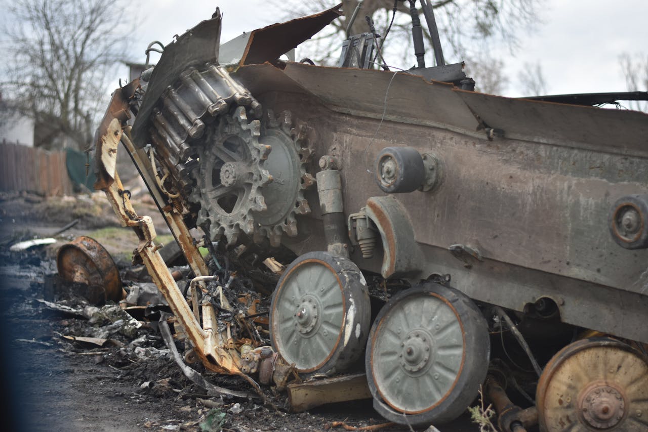 Close-up of a damaged military tank wreckage in an outdoor setting.